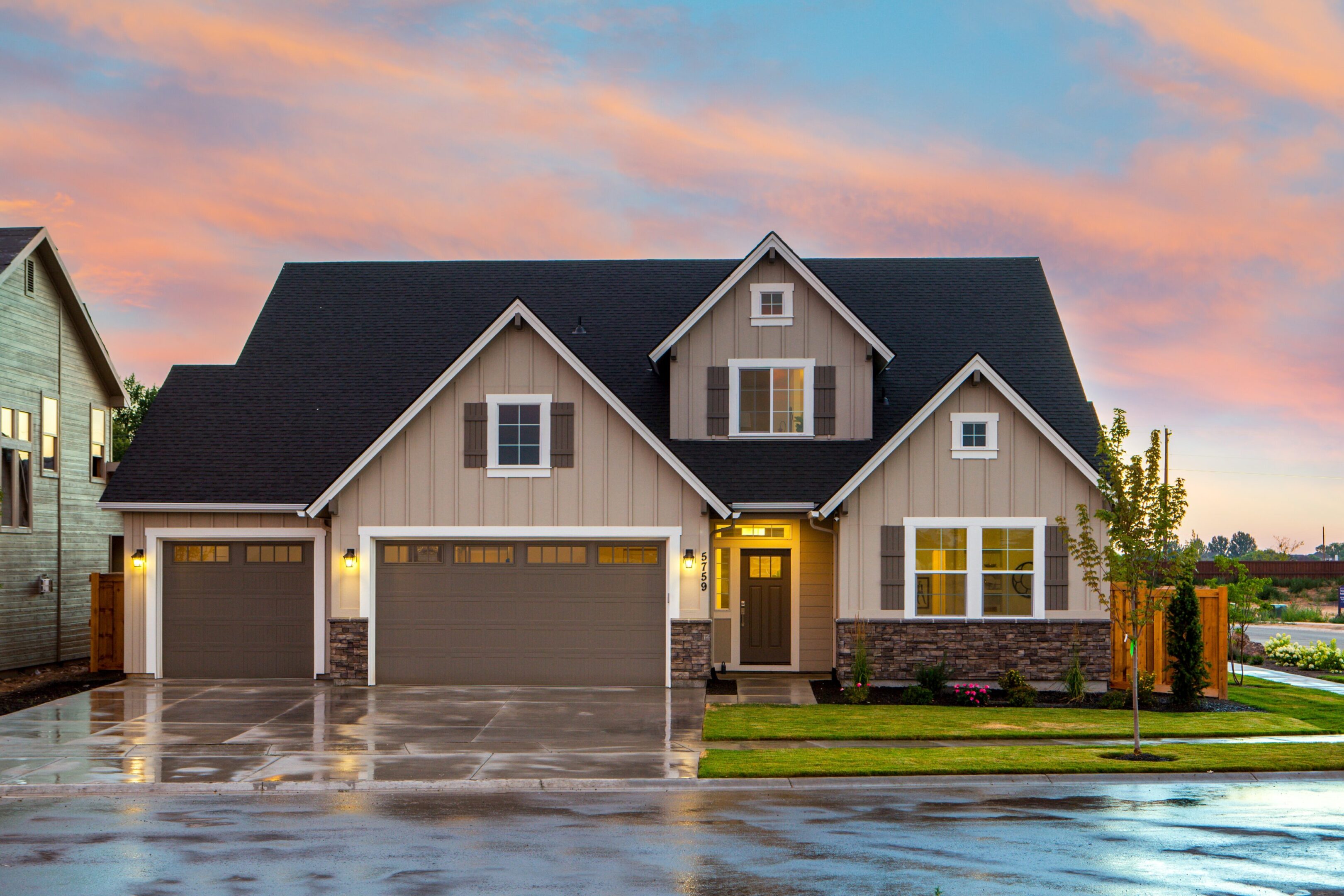 A house with a garage and water in the driveway.