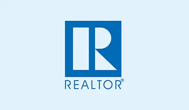 A blue and white logo for realtor. Com