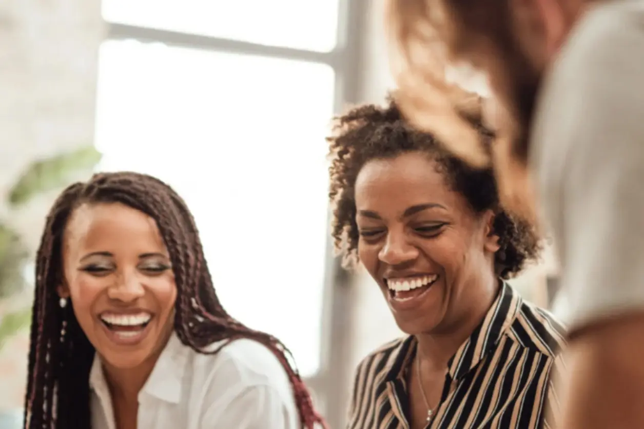 Two women laughing and talking to each other.